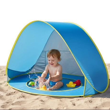 Dijete se igra u plavom šatoru sa mini bazenom na plaži